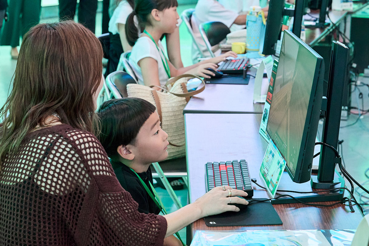保護者と一緒にマインクラフトの建築に取り組む子ども