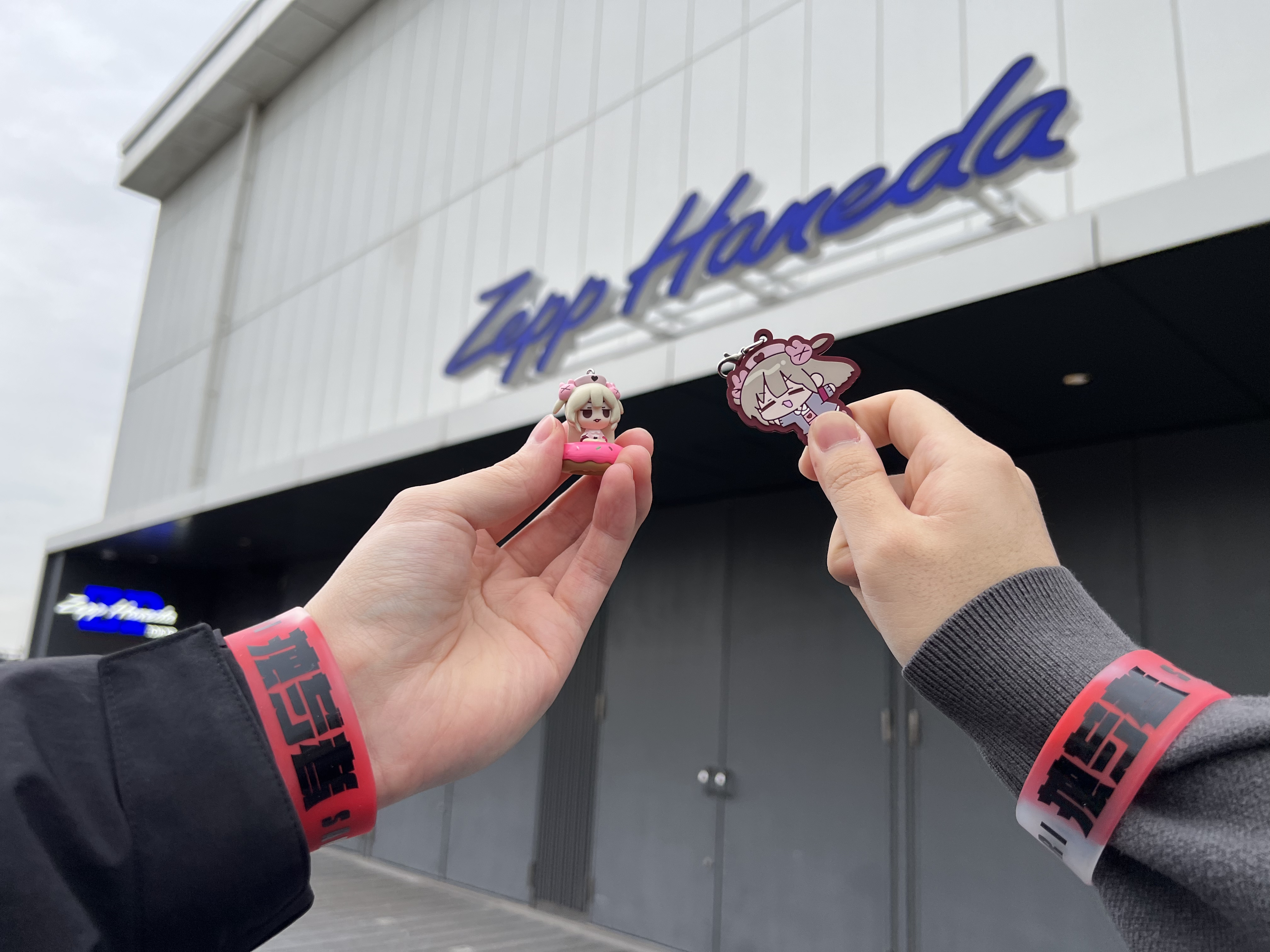 リストバンドを付けてzepp hanedaの前で写真撮影